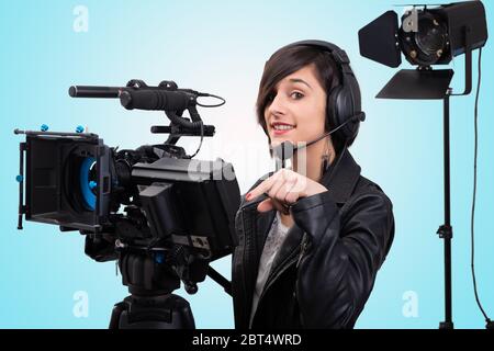 Una giovane donna con videocamera professionale, DSLR Foto Stock