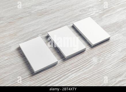 Tre blank business cards su luce sullo sfondo di legno. Il Branding mockup. Foto Stock