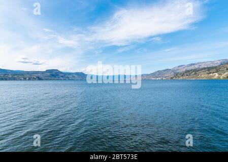 Vista dal Naramata Wharf Park del lago Okanagan, cielo blu e montagne lontane nella Okanagan Valley Foto Stock