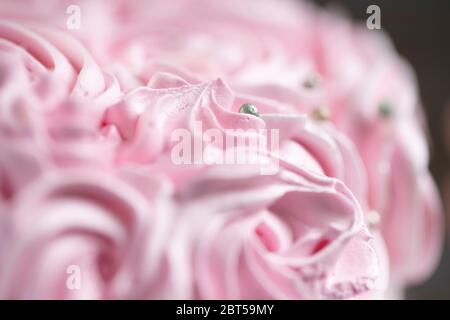 Torta di crema fresca alla fragola con palle di cioccolato in argento sparse intorno alla crema montata, di colore rosa e bianco Foto Stock