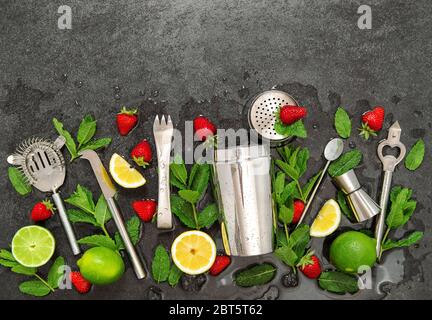 Accessori per barre. Ingredienti caipirinha cocktail drink. Fragola, lime, menta, limone, ghiaccio Foto Stock