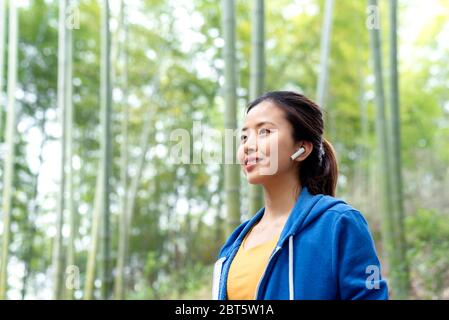 Una giovane donna asiatica che cammina nella foresta di bambù