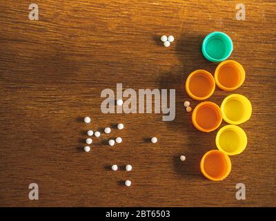 Bottiglie di pillole omeopatiche/globuli con fondo marrone di legno Foto Stock