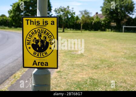 cartello di guardia di quartiere accanto a un parco giochi in un villaggio, copyspace sulla destra Foto Stock