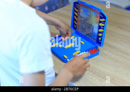 Un ragazzo gioca a casa un gioco da tavolo Foto Stock