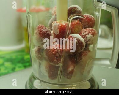 fragole surgelate fresche e succose in un primo piano del frullatore Foto Stock