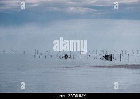 Spiaggia di Sandyhills con reti di pali di salmone in disuso e Robin Rigg wind farm Foto Stock