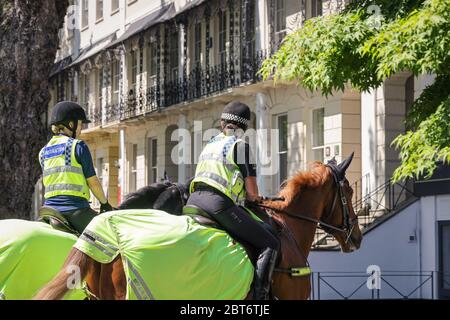 Due ufficiali di polizia femminili sul centro di Cheltenham pattugliamento di cavallo durante la quarantena di epidemia di coronavirus maggio 2020 Foto Stock