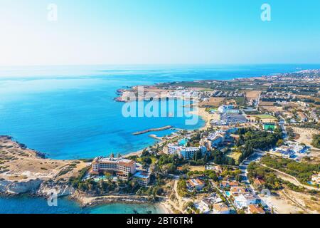 Vista panoramica aerea del paesaggio di Cipro con alberghi, baie con spiagge e acque cristalline del mediterraneo. Viaggio a Cipro Concept con spazio di copia. Foto Stock