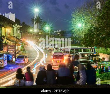 Foto notturna di strada trafficata a Fort Galle, Sri Lanka, con sentieri leggeri dalle auto di passaggio e il famoso faro di Galle all'estremità della fra Foto Stock