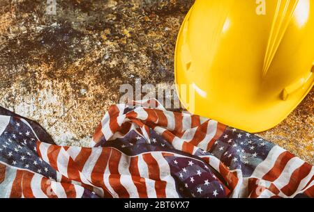 Happy Labor Day USA patriottico, giallo casco costruzione bandiera USA sopra legno ponte tavolo sfondo. Foto Stock