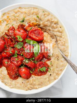 risotto cremoso con pomodori arrostiti e basilico Foto Stock