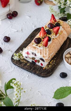 Meringa con frutti di pralina al pistacchio fresco e panna montata e crema di formaggio a cagliata. Dessert estivo Foto Stock