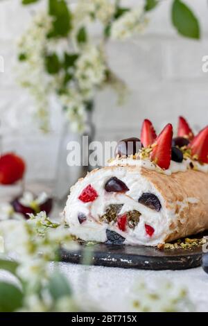 Meringa con frutti di pralina al pistacchio fresco e panna montata e crema di formaggio a cagliata. Dessert estivo Foto Stock