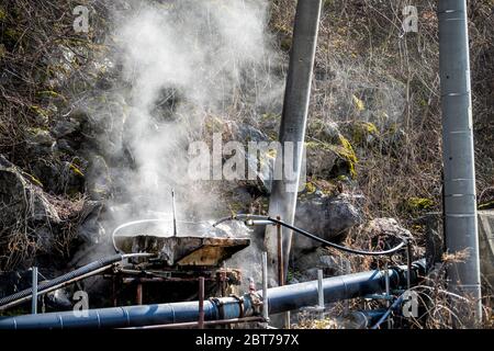 Il vapore delle sorgenti calde scorre attraverso i tubi a Takayama, Giappone nella prefettura di Gifu vista dalla strada che conduce ai villaggi di Okuhida e Shinhotaka Ropeway copr Foto Stock