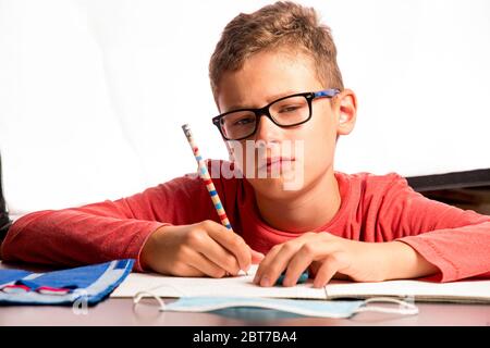 il bambino stanco non può imparare più e deve fare tutte le lezioni a casa Foto Stock