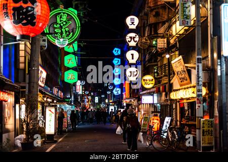 Osaka, Giappone - 13 Aprile 2019: Minami Namba famosa strada con persone che camminano in notte oscura e illuminati edifici al neon verde rosso con carta rossa la Foto Stock