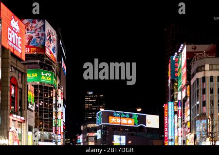 Tokyo, Giappone - 3 aprile 2019: Shinjuku ward centro città vicino Kabukicho strada con al neon colorato luci della città illuminato skyline e ammiratore Foto Stock