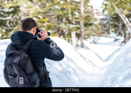 Takayama, Giappone e ritorno dell'uomo che scattano foto del sentiero innevato nella pista di Shinhotaka nella prefettura di Gifu, con alberi Foto Stock