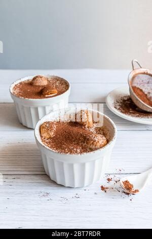 Classico dessert tiramisù in vaso bianco su sfondo grigio Foto Stock