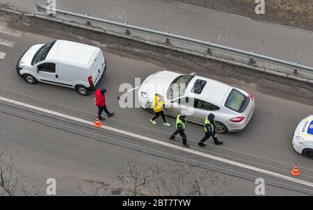 KIEV, UCRAINA - 02 FEBBRAIO 2020: Una macchina della polizia arriva a un incidente stradale di attraversamento pedonale con i conducenti non identificati in piedi fuori t. Foto Stock