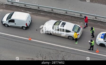 KIEV, UCRAINA - 02 FEBBRAIO 2020: Una macchina della polizia arriva a un incidente stradale di attraversamento pedonale con i conducenti non identificati in piedi fuori t. Foto Stock