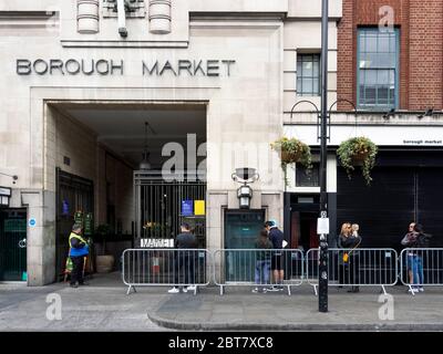 Londra. REGNO UNITO. 23 maggio 2020 a mezzogiorno. Vista delle persone che si accodano all'ingresso del Borough Market durante l'epidemia. Foto Stock