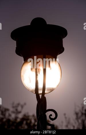 Vecchia lampada streetlight sul Mound illuminato dalla luce del sole dalla stazione di Waverley Edimburgo Foto Stock
