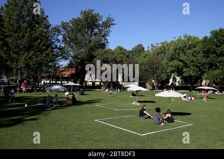 Cascais, Portogallo. 23 maggio 2020. La gente gode del sole mentre si siede in parecchie zone squadrate-fuori create dal comune per assicurare la distanza sociale durante la pandemia di COVID-19 nel parco di Alagoa a Cascais, Portogallo, 23 maggio 2020. Credit: Pedro Feuza/Xinhua/Alamy Live News Foto Stock