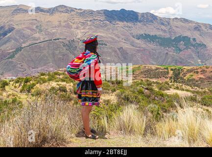 Donna indigena Quechua in abiti tradizionali che si affaccia sulla Valle Sacra degli Inca vicino a Cusco, Perù. Foto Stock