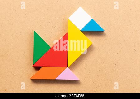 Puzzle tangram colore in forma di uccello o anatra su bacground di legno Foto Stock