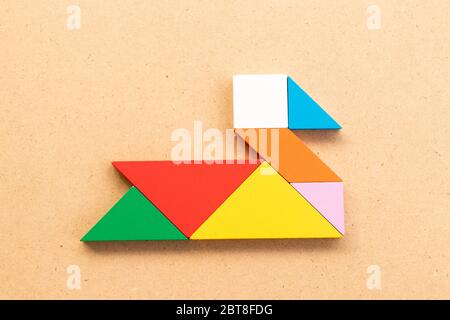 Puzzle tangram colore in cigno o anatra forma su legno bacground Foto Stock