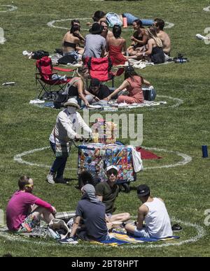 San Francisco, Stati Uniti. 24 maggio 2020. Un venditore di snack mascherato spinge il suo carrello attraverso i gruppi in circoli pre-disegnati nel Parco Delores a San Francisco sabato 23 maggio 2020. Il clima caldo e un fine settimana di vacanza hanno portato fuori migliaia per esercitarsi i loro propri marchi di distanza sociale. Photo by Terry Schmitt/UPI Credit: UPI/Alamy Live News Foto Stock