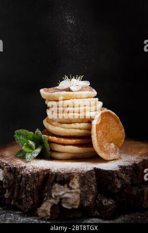 Cibo alla moda durante la quarantena Coronavirus Covid-19 - minuscoli pancake. Poffertjes, frittelle olandesi. Colazione per bambini, mini pancake. Foto Stock