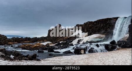 Acqua dalla cascata che spruzzi su un fiume roccioso. La cascata Oxarfoss nel Parco Nazionale di pingvellir Thingvellir islanda Foto Stock