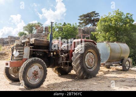 Vecchio trattore con autocisterna in parcheggio di fronte alla riserva forestale di Tannourine, Libano Foto Stock