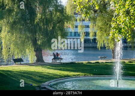 Persone irriconoscibili godono di un'atmosfera primaverile in una serata primaverile lungo il fiume Motala a Norrkoping, Svezia Foto Stock