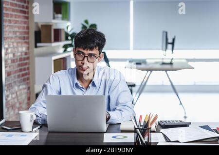 Imprenditore asiatico di Woking con il computer portatile e il foglio di lavoro sulla scrivania in ufficio.workflow digitale business online il concetto di stile di vita Foto Stock