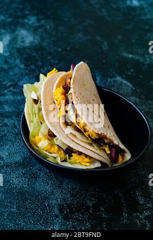 Turco stile messicano Taco CIG Kofte con fagioli Kidney, cipolle rosse, formaggio Cheddar grattugiato e salsa sciroppo di melograno. Fast food tradizionale. Foto Stock