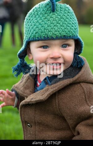 Adorabile ragazzo di un anno che grinning in modo allegro ed eccitato per essere corsa circa all'aria aperta: Sheffield Park, East Sussex, Inghilterra, Regno Unito. MODELLO RILASCIATO Foto Stock