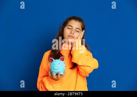 Adorabile ragazza preteen con maglia gialla su sfondo blu Foto Stock