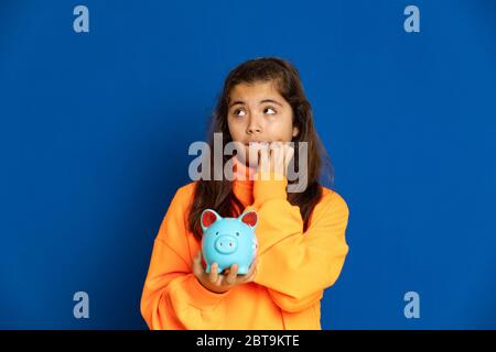 Adorabile ragazza preteen con maglia gialla su sfondo blu Foto Stock