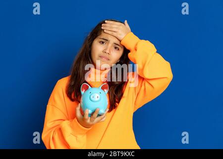 Adorabile ragazza preteen con maglia gialla su sfondo blu Foto Stock