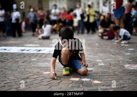 Torino, Italia. 23 maggio 2020. TORINO - 23 maggio 2020: Un bambino dipinge a terra con gesso durante una manifestazione per richiedere la riapertura delle scuole a settembre. (Foto di Nicolò campo/Sipa USA) Credit: Sipa USA/Alamy Live News Foto Stock