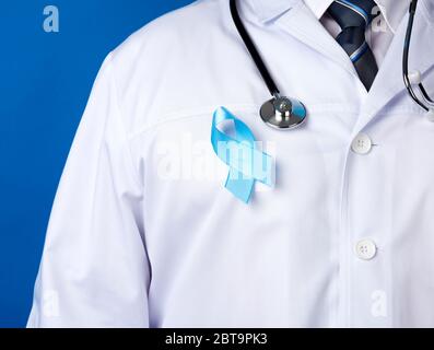 nastro di seta blu a forma di anello fissato su un abito bianco. Consapevolezza del cancro della prostata. Concetto di giornata mondiale del cancro