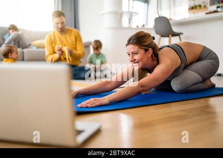 Giovane donna sta esercitando lo yoga a casa. Fitness, allenamento, vita sana e concetto di dieta. Foto Stock