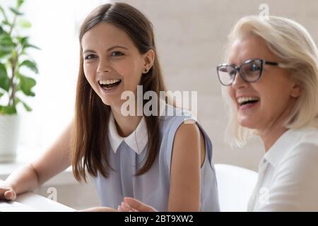 I dipendenti donne felici e diversi ridono a parlare sul posto di lavoro Foto Stock
