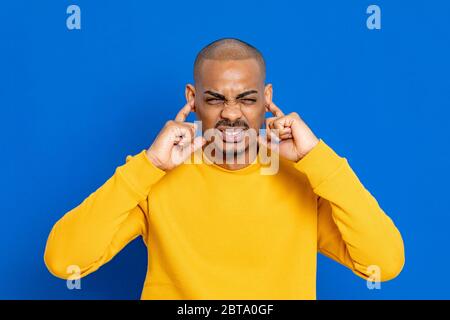 Ragazzo africano con una maglia gialla su sfondo blu Foto Stock