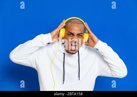 Un ragazzo africano che indossa una felpa bianca su sfondo blu Foto Stock