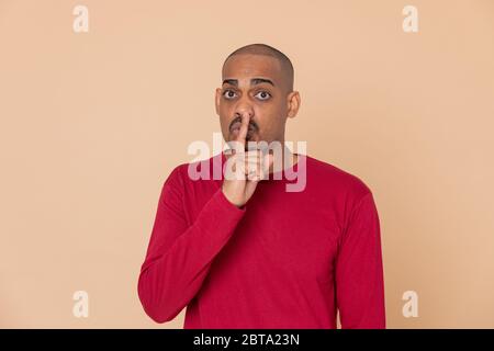 Ragazzo africano con una maglia rossa su sfondo giallo Foto Stock